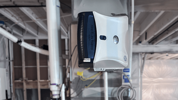 Installed humidifier attached to furnace in unfinished basement