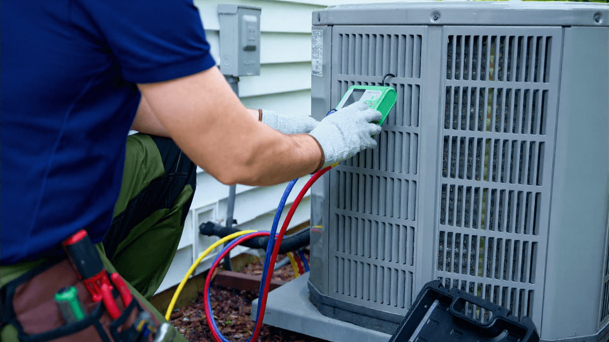 HVAC tech performing maintenance on a condensor