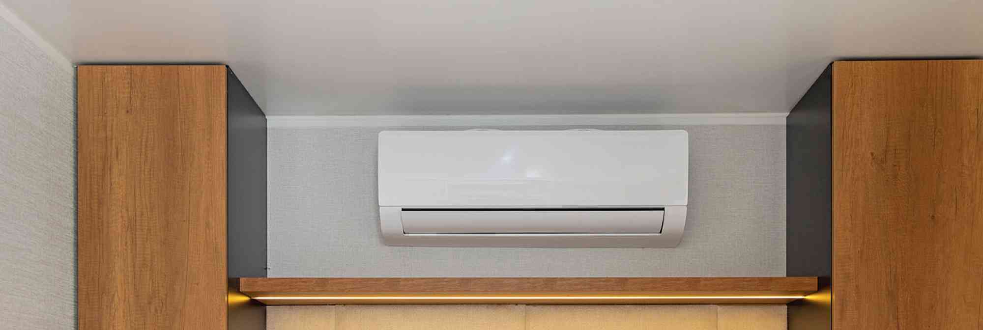 White Air Conditioner Mini Split Unit Mounted at Wall in Bedroom